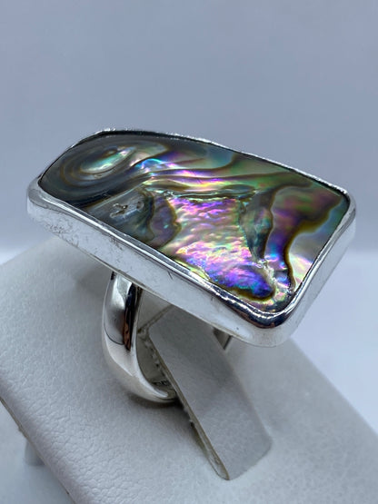 Detalle de la piedra iridiscente con arcoíris de colores reflejados en la mano
