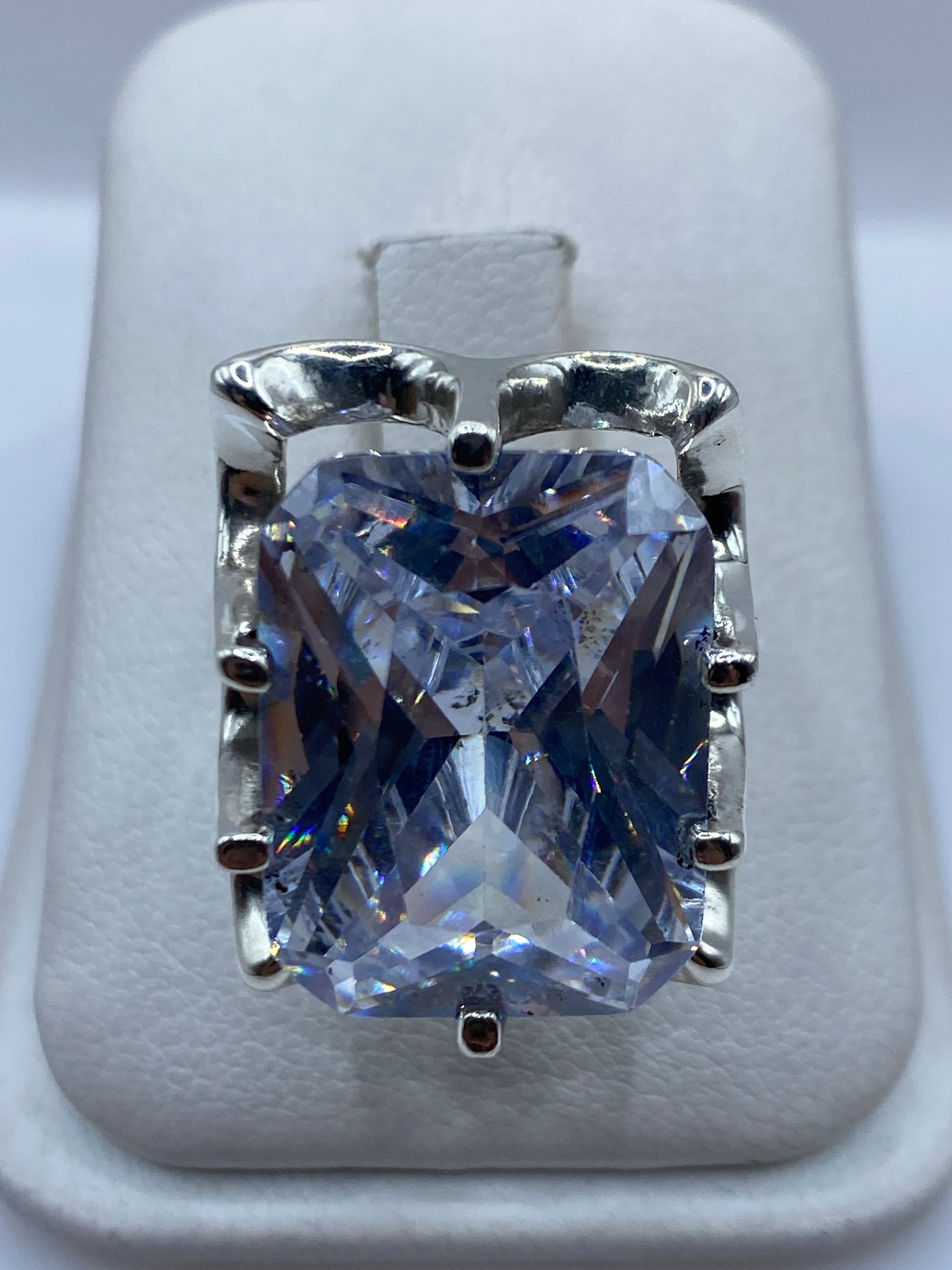Anillo de plata solitario con circonia cristalina en engaste clásico, vista frontal sobre dedo