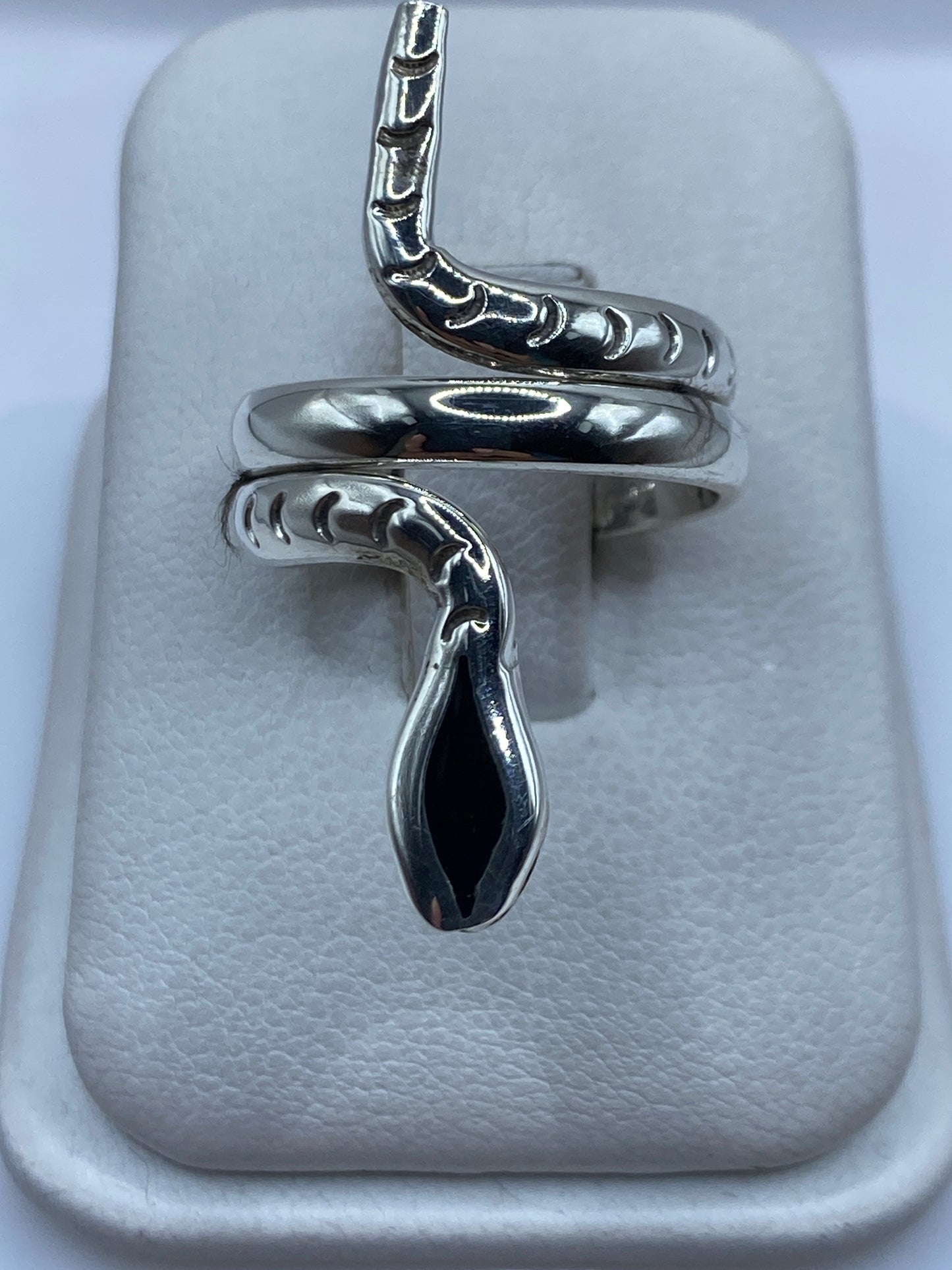 Anillo envolvente de plata con ónix negro brillante en la mano de una mujer
