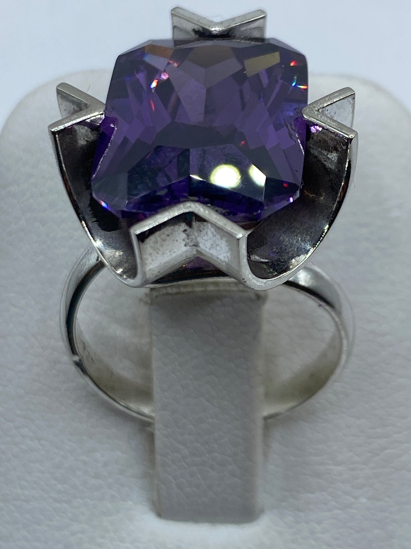 Anillo de plata con circonia morada facetada en mano de mujer, mostrando el brillo y fuego de la piedra
