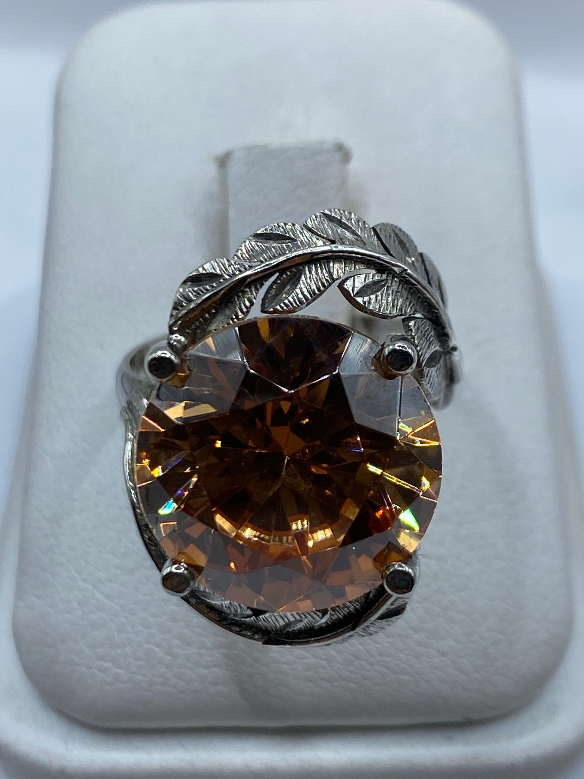 Anillo de plata solitario con circonia champagne y motivo de hojas en relieve textural visto de frente