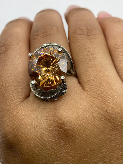 Anillo sobre dedo mostrando brillo cálido de la circonia champagne y textura de relieve