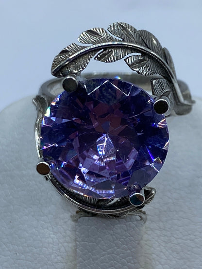 Anillo de plata solitario lavanda en la mano de una mujer, mostrando el brillo y color
