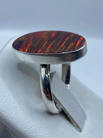Detalle del ópalo de fuego natural mostrando juego de colores rojo, naranja, amarillo y verde