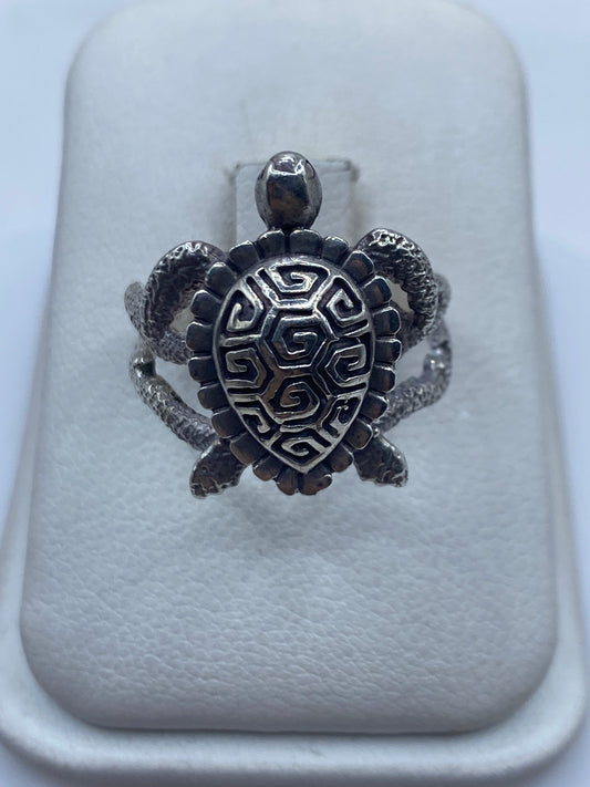 Anillo tortuga prehispánico en plata .950, caparazón geométrico con espiral grabada, sobre dedo de mujer