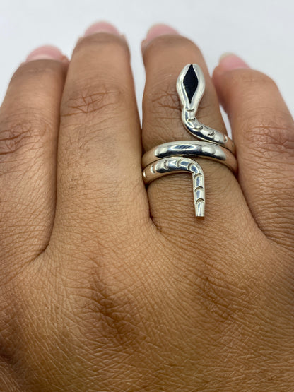 Anillo ónix negro en mano femenina mostrando el diseño serpiente envolvente