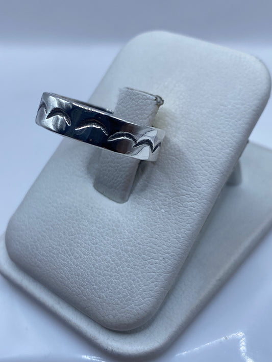 Vista lateral del anillo unisex mostrando el grabado profundo de ondas