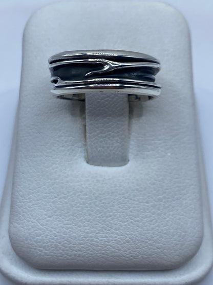 Anillo de plata con bandas superpuestas en los dedos de una persona