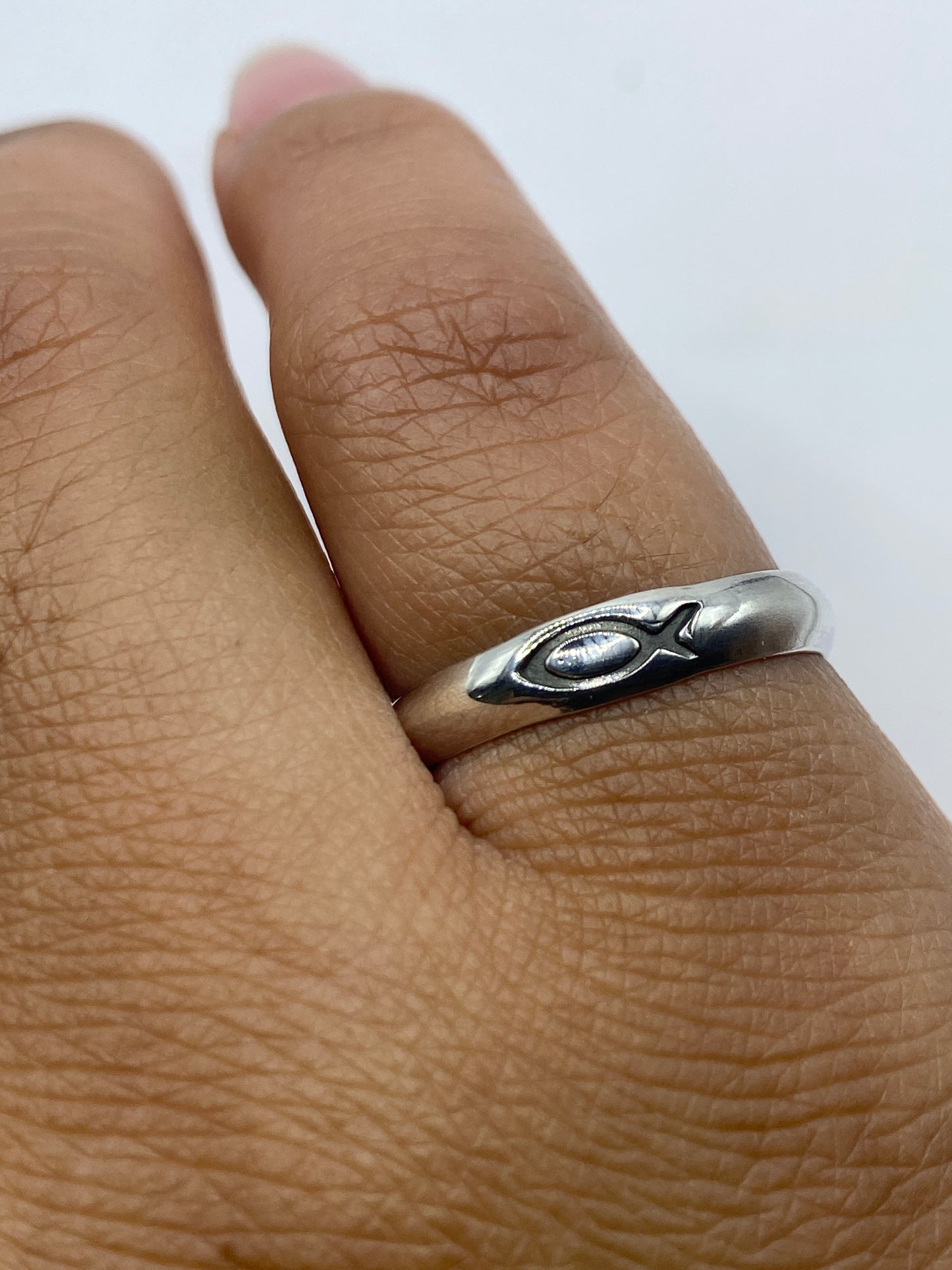 Anillo de plata sobre fondo gris mostrando el sello 925 MEXICO en el interior