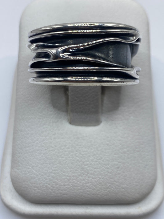 Anillo de plata con bandas superpuestas en posición horizontal sobre fondo blanco