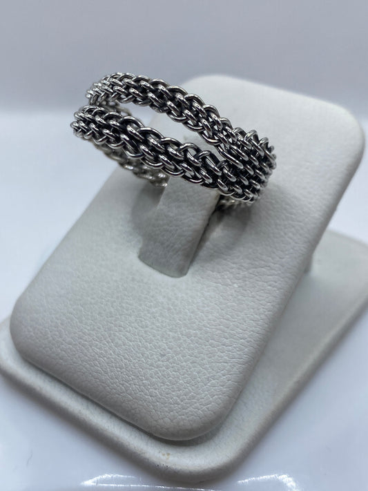 Anillo trenzado en la mano mostrando textura de dos hilos entrelazados