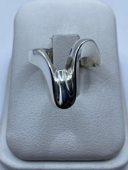 Anillo de plata pulido minimalista en dedo de mujer con acabado espejo