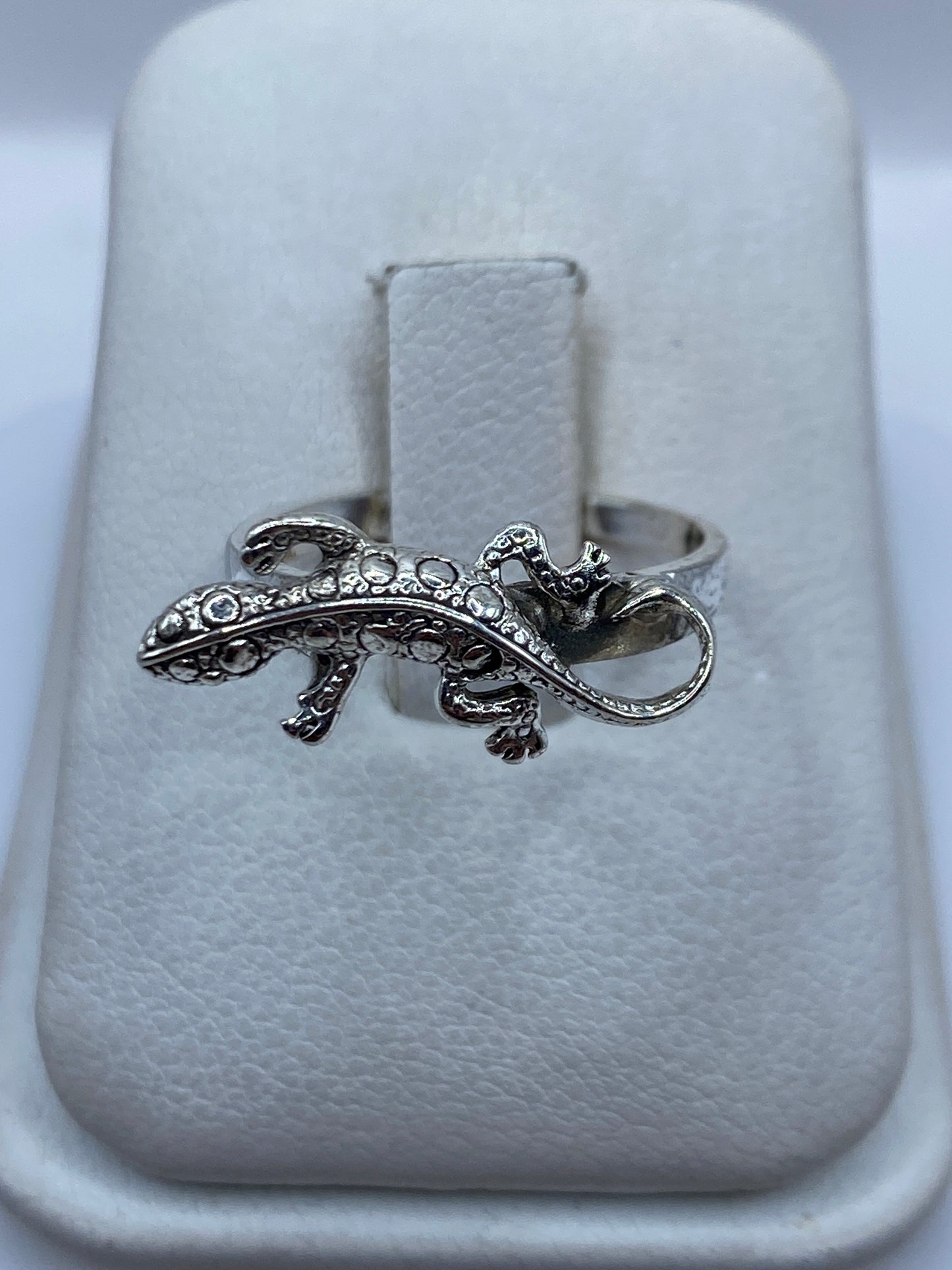 Anillo de plata artesanal con figura de iguana en relieve, sobre estuche blanco