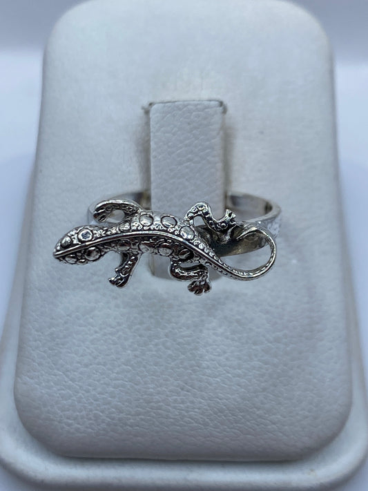 Anillo de plata artesanal con figura de iguana en relieve, sobre estuche blanco
