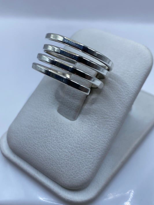 Bandas de plata minimalistas en la mano, mostrando el diseño liso y pulido