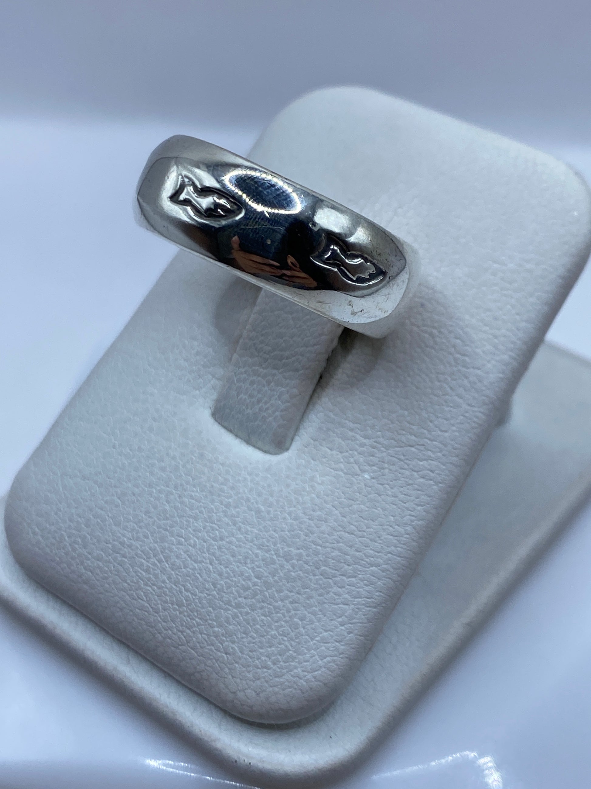 Anillo banda de plata en dedo mostrando el acabado espejo y el sello .925