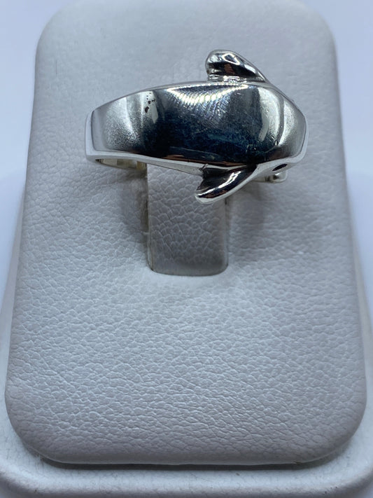 Anillo de plata con forma de pájaro minimalista en la mano de una mujer