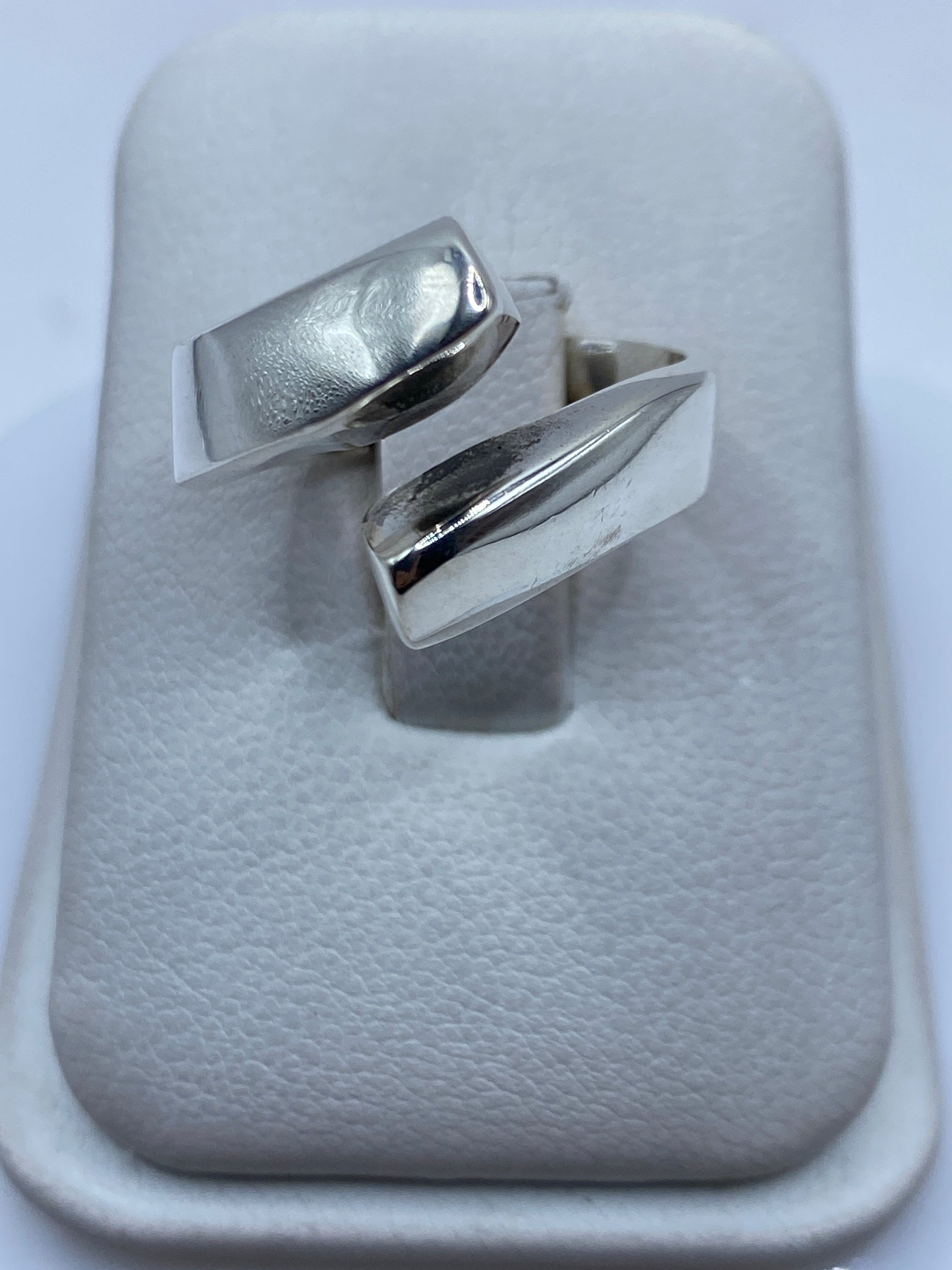 Anillo de plata ajustable con diseño geométrico moderno en presentación de tienda