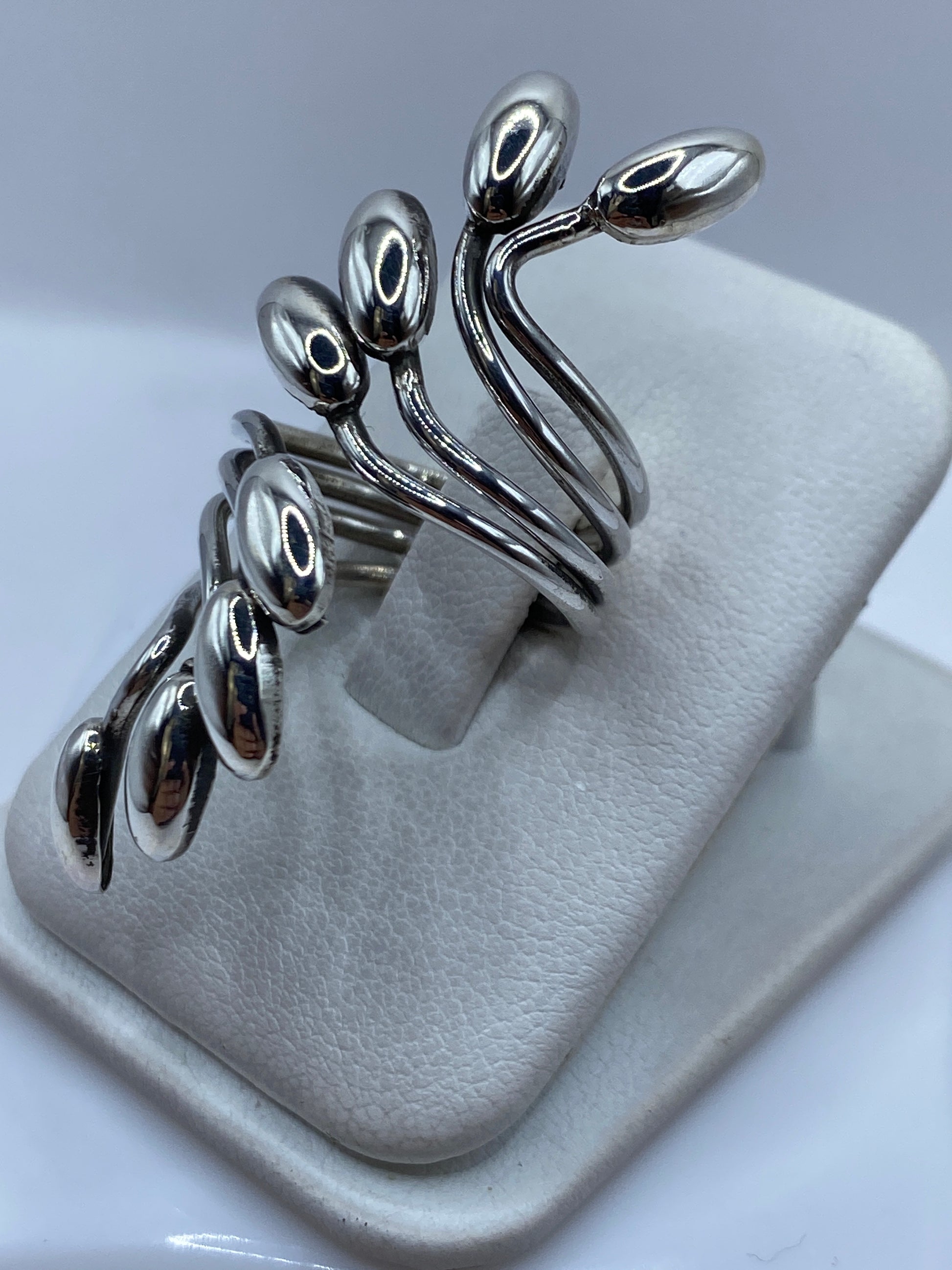 Anillo de plata flores naturales puesto en la mano mostrando el pulido espejo