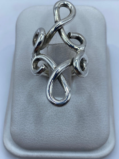 Anillo de plata en calado con diseño geométrico abierto, vista frontal en dedo