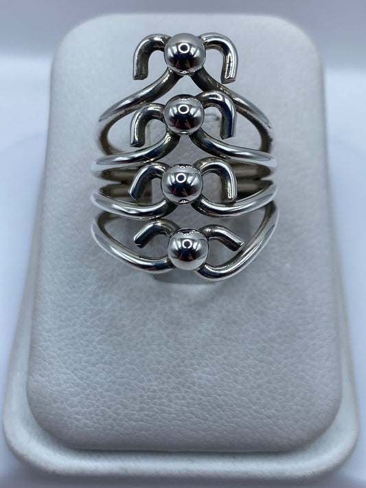Anillo de plata en calado con motivos geométricos escultóricos en la mano de una mujer