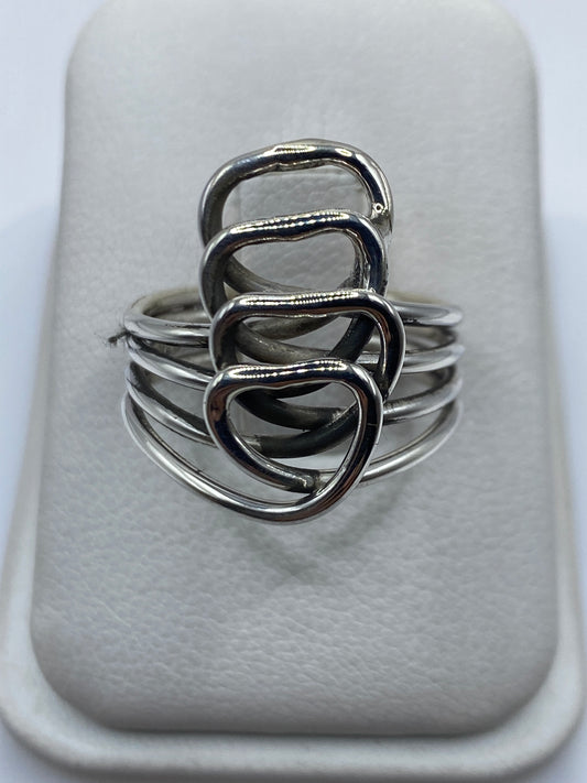 Anillo de plata calado con cuatro corazones entrelazados en mano de mujer