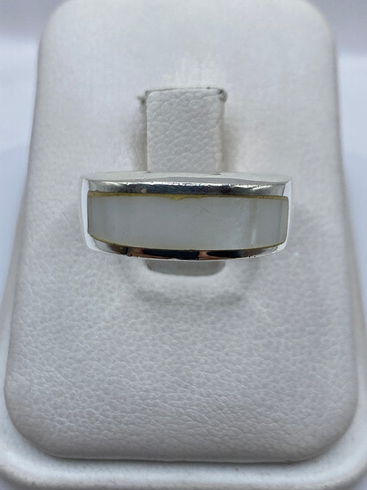 Anillo de plata con perla blanca redonda engastada en el centro, vista frontal