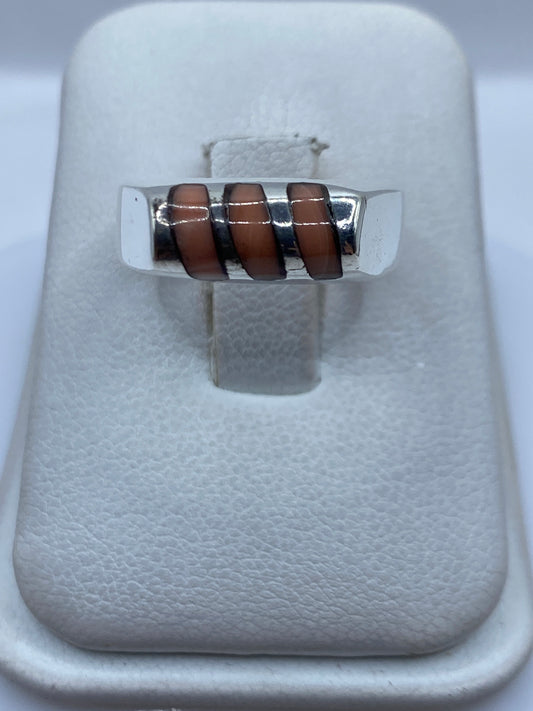 Anillo de plata .925 con coral rojo engastado a mano, sobre presentador blanco