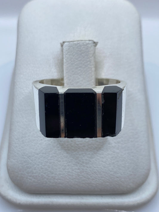 Anillo de plata con tres bloques de ónix negro, visto desde arriba en estuche blanco