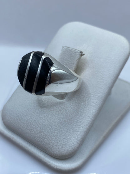 Anillo de ónix negro en mano, mostrando el tamaño y presencia de la piedra