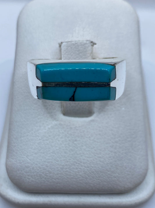 Anillo de plata con turquesa azul cielo engastada en diseño geométrico sobre fondo blanco