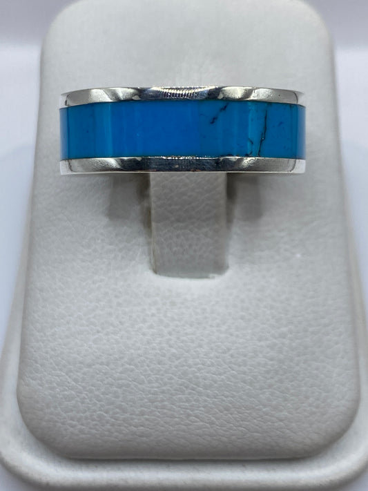 Anillo de plata .950 con turquesa azul cielo en banda ancha, vista frontal sobre dedo