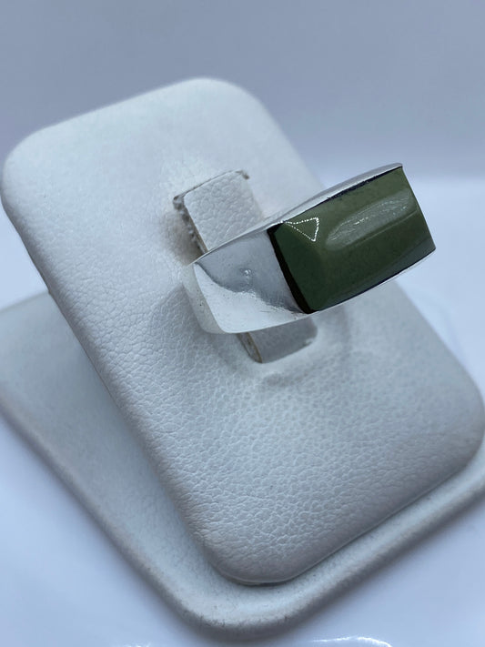 Detalle lateral del anillo mostrando el engaste a mano y la piedra verde