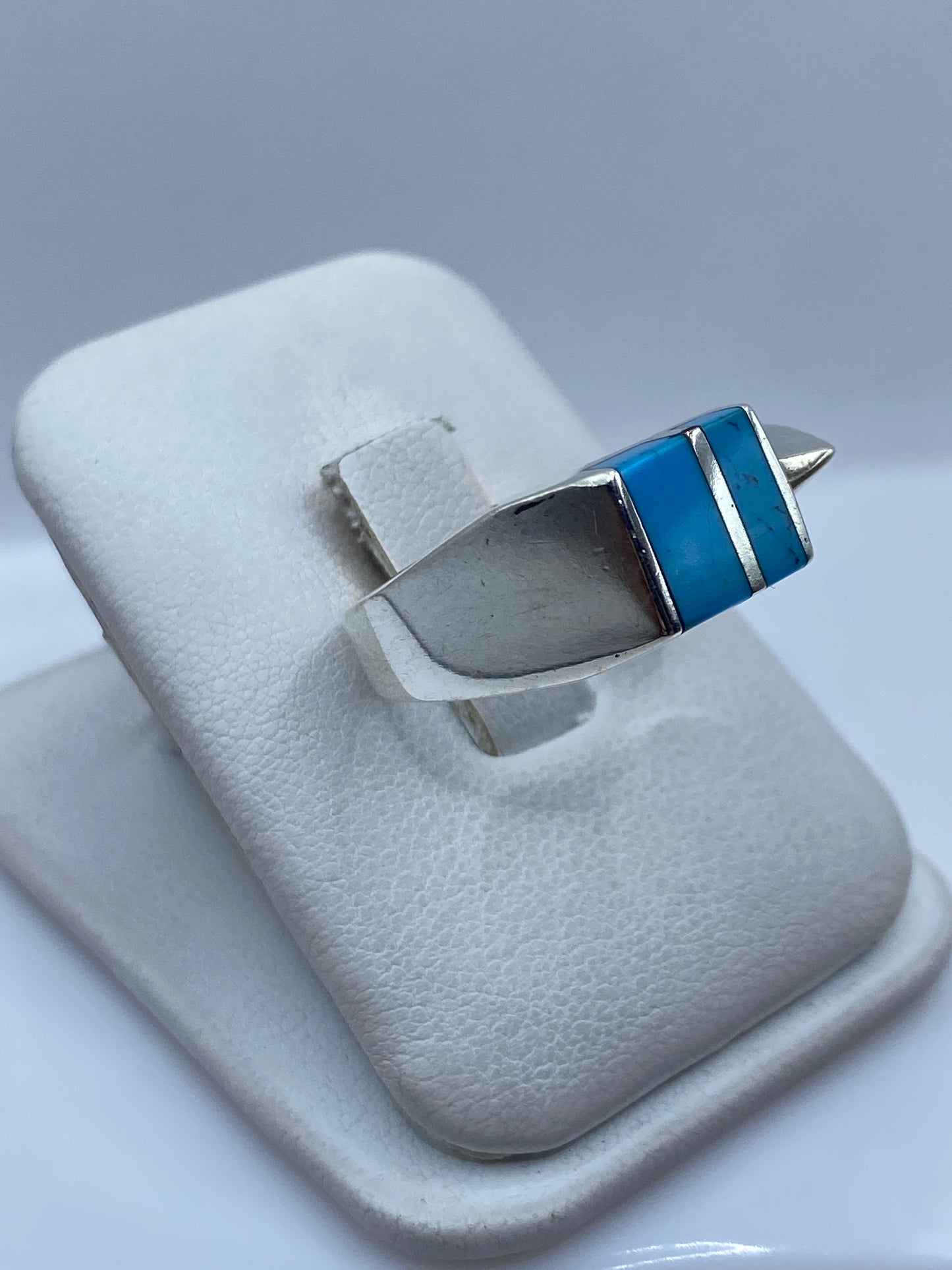 Detalle lateral del anillo mostrando el engaste a mano de la turquesa