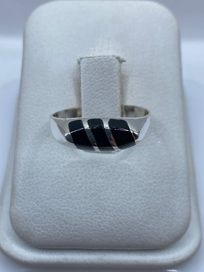 Anillo de plata con tres piedras de ónix negro engastadas, sobre estuche blanco