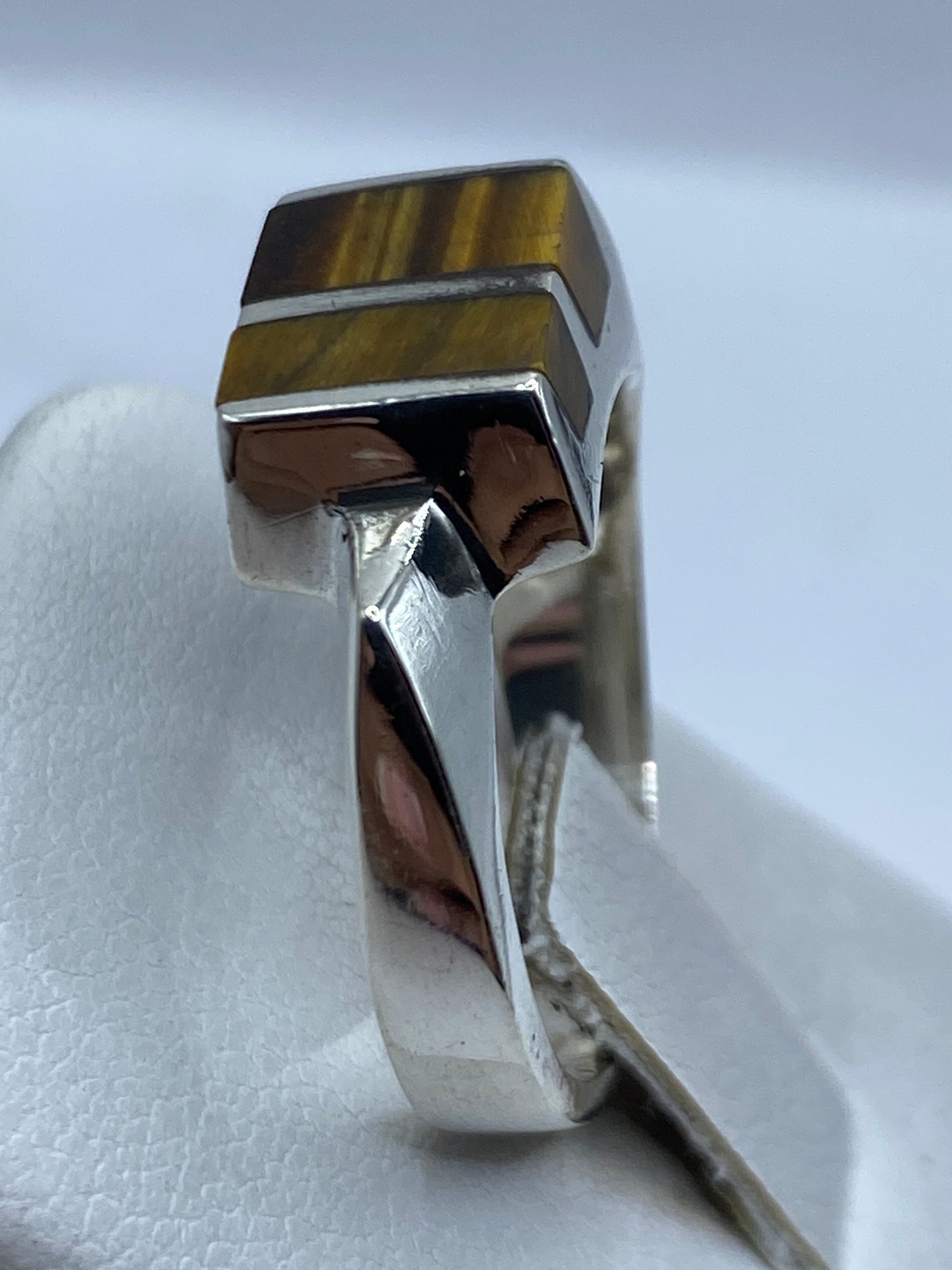 Detalle de la piedra café engastada en plata, capturando la luz