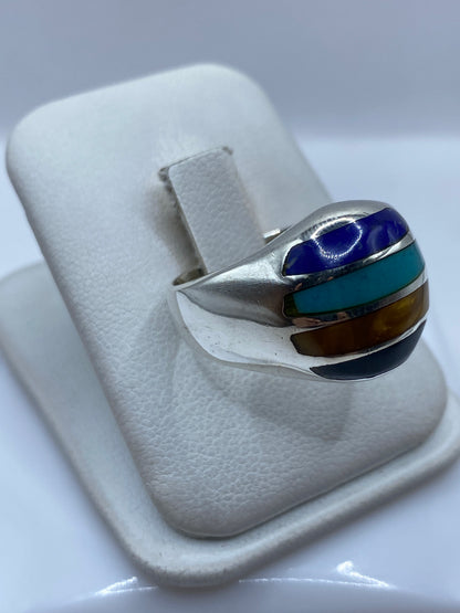 Anillo turquesa en mano mostrando los cuatro colores de piedra engastada
