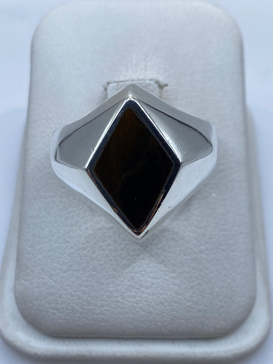 Anillo de plata solitario con piedra cafe engastada a mano, vista frontal en estuche