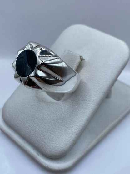 Anillo de plata ónix negro en la mano mostrando el engaste estructurado