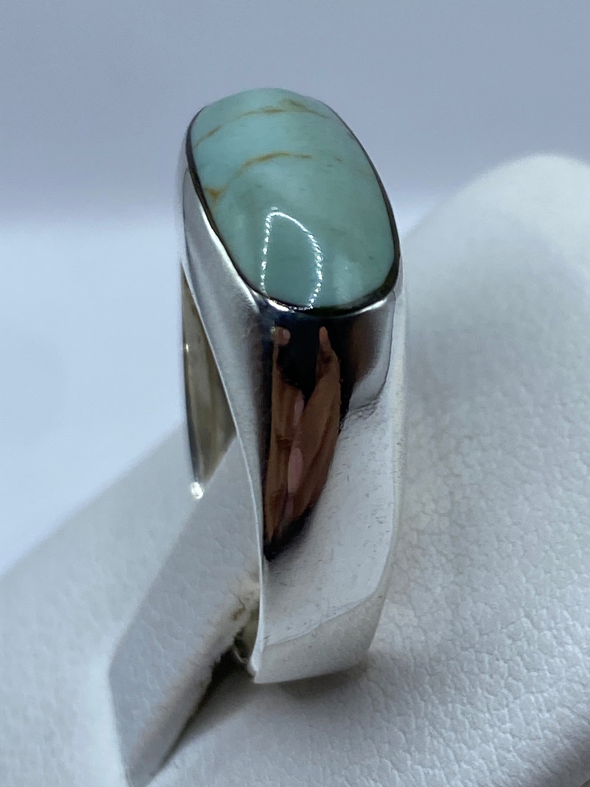 Detalle del anillo en la mano mostrando el color azul cielo de la piedra