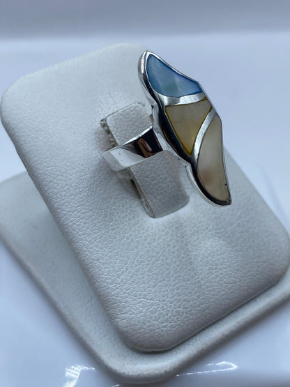 Detalle lateral del anillo mostrando la incrustación de la perla y el acabado pulido de la plata