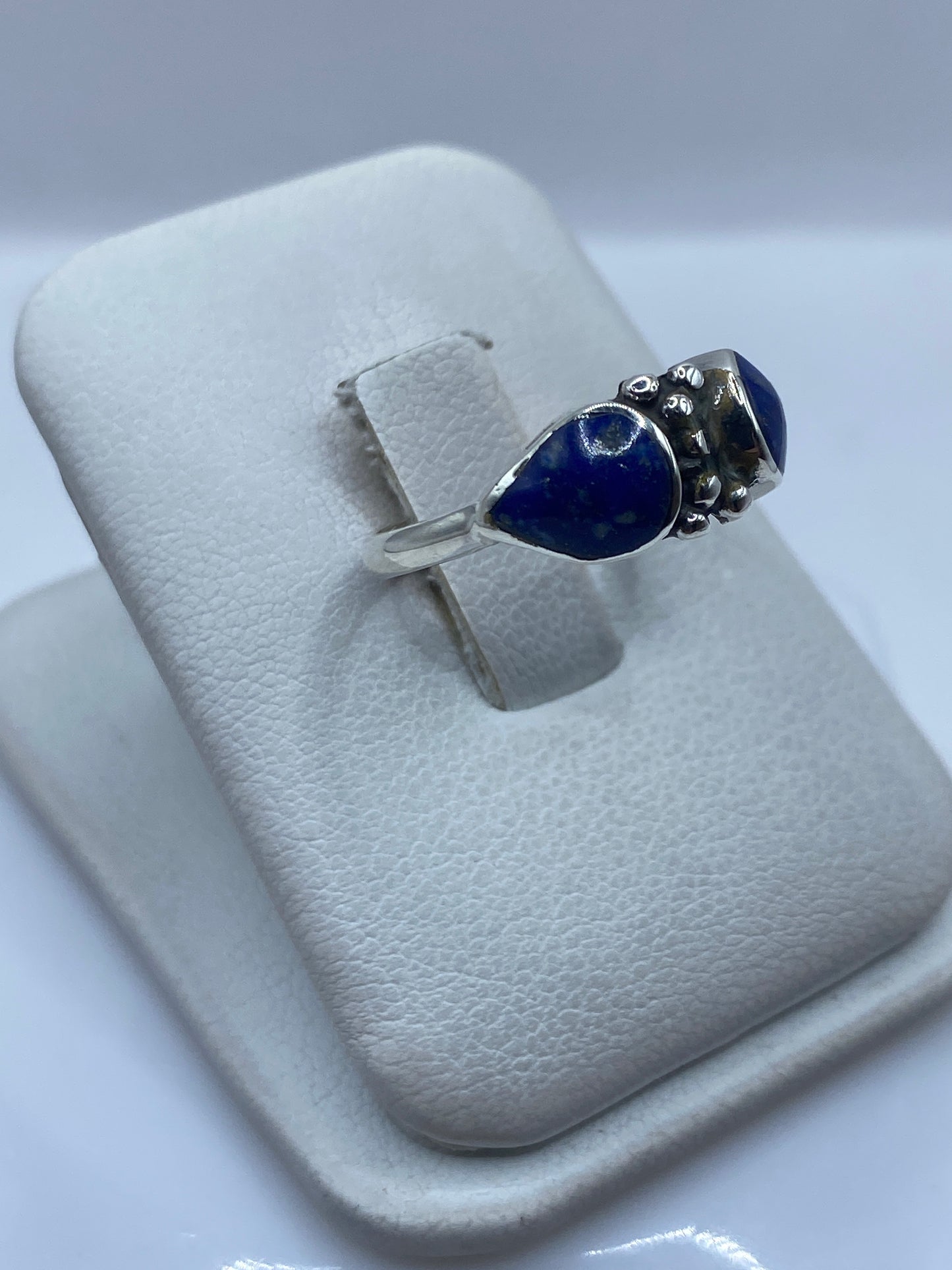Anillo de plata .950 con piedras azules vista lateral en dedo, mostrando el perfil elegante