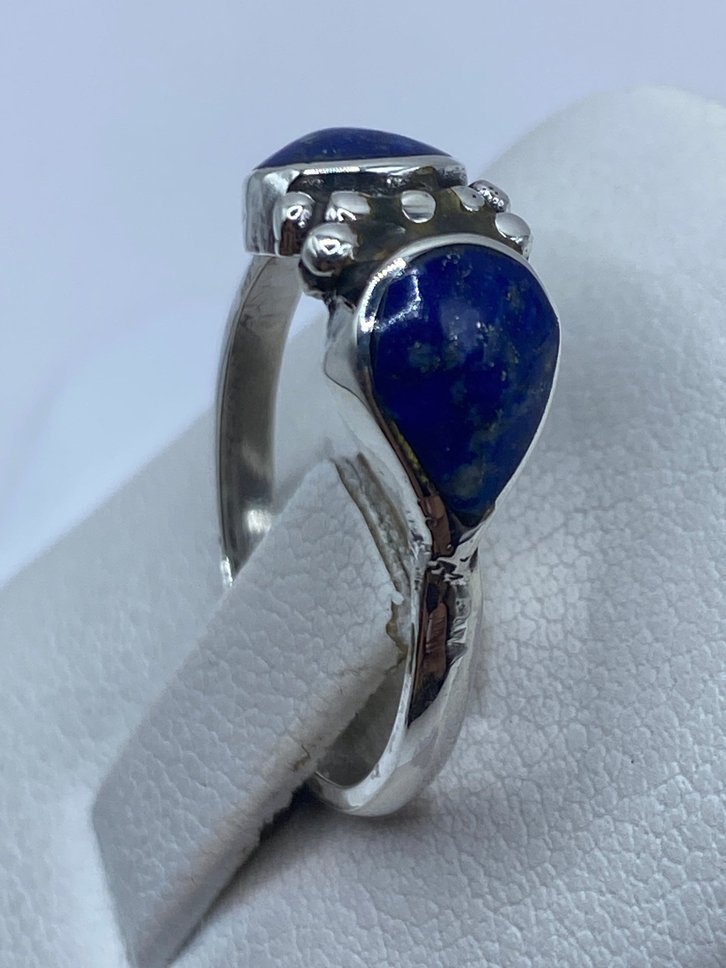 Detalle del engaste a mano de piedras azules en plata .950
