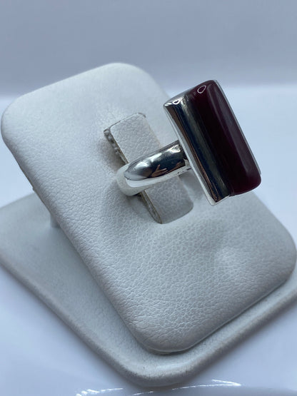 Detalle frontal del anillo de coral rojo engastado en marco de plata pulida