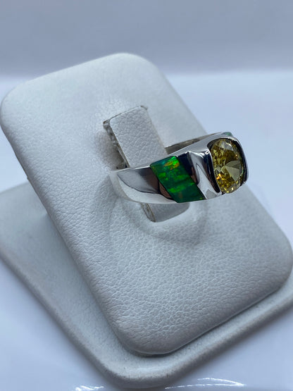 Vista lateral del anillo combinado con ópalo de fuego y perfiles verdes de incrustación
