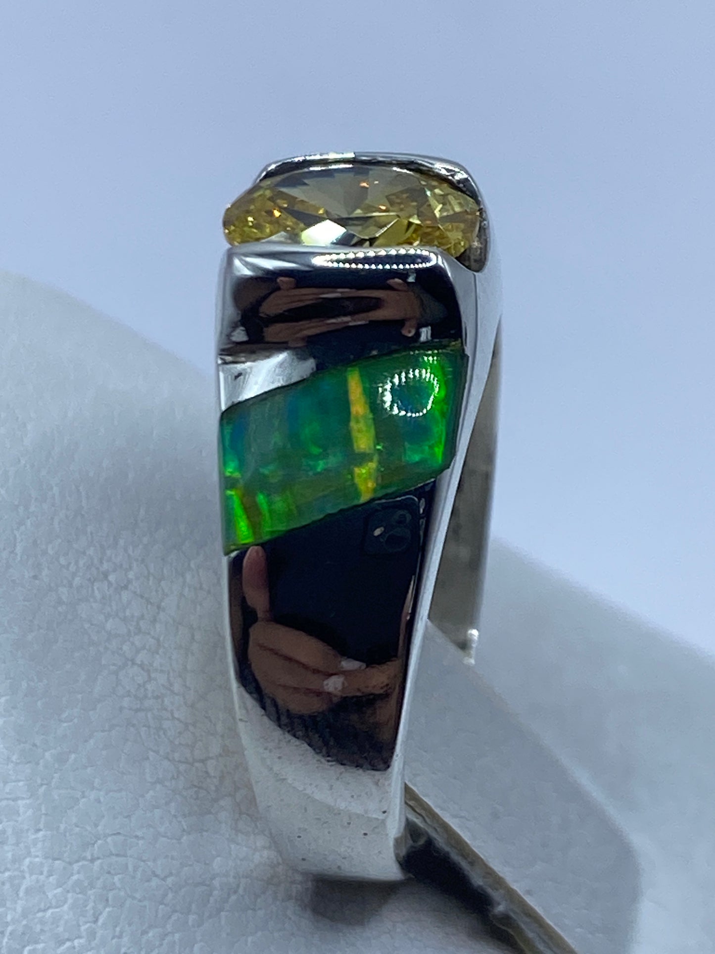Detalle del ópalo de fuego verde limón reflejando luz, engastado en plata .950