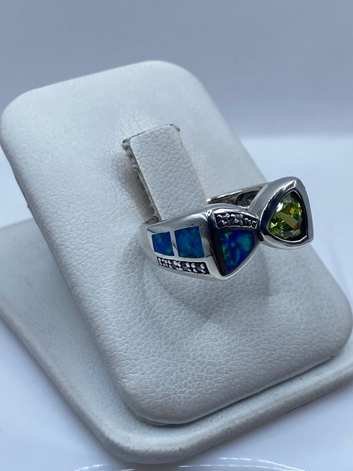 Detalle del ópalo de fuego azul reflejando luz en el anillo de plata de Taxco