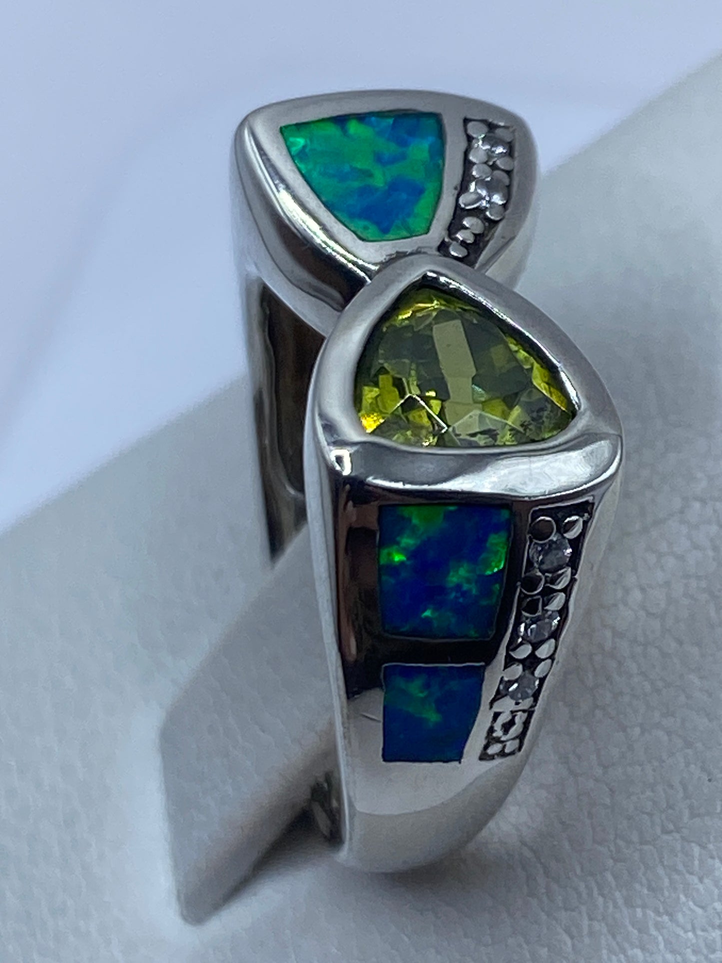 Anillo puesto en dedo mostrando el diseño minimalista y el brillo del ópalo