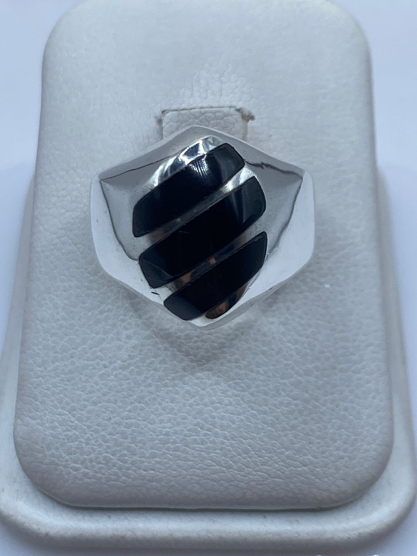 Anillo de plata .925 con ónix negro engastado en la mano de una persona