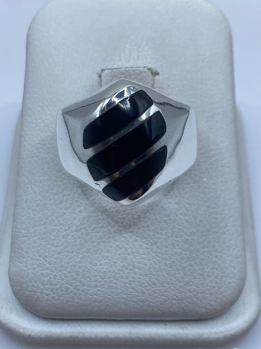 Anillo de plata .925 con ónix negro engastado en la mano de una persona
